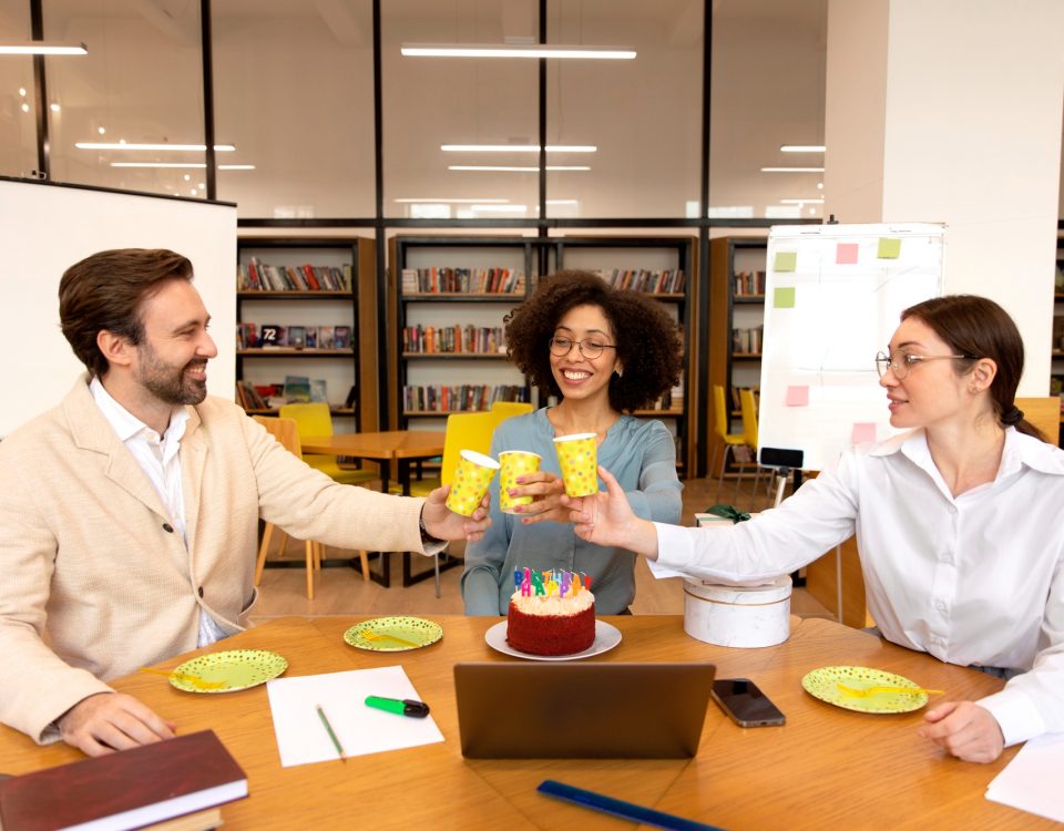 Compañeros de trabajo de tiro medio tintineando vasos